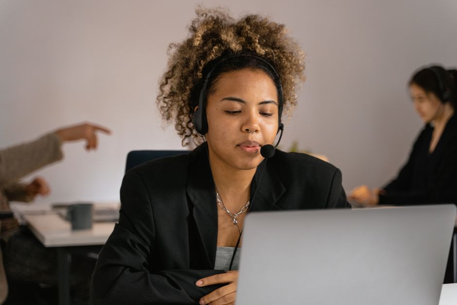 Mulher afro-americana trabalhando em um call center com fones de ouvido.